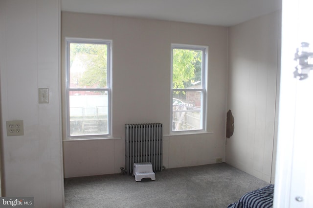 carpeted spare room featuring radiator heating unit