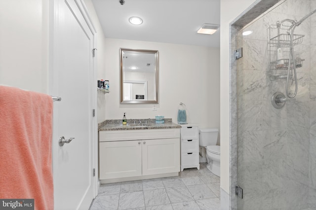 bathroom featuring a shower with door, vanity, and toilet