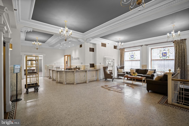 living room featuring a tray ceiling, ornamental molding, and a chandelier