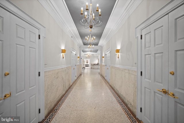 hall with crown molding and a chandelier