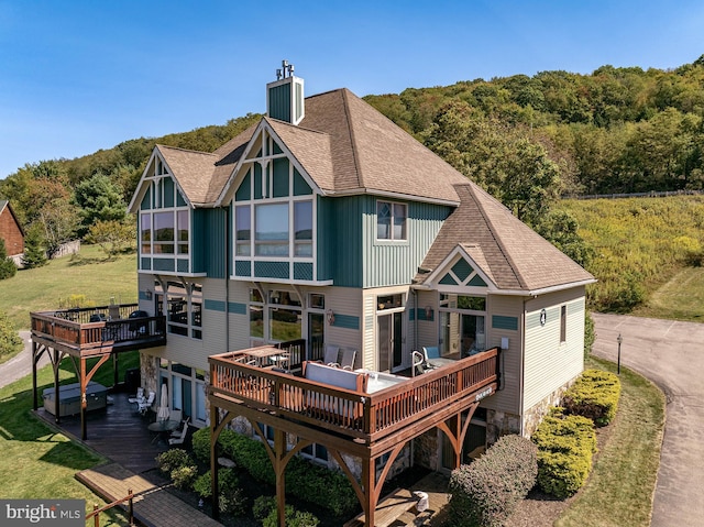 rear view of house featuring a wooden deck