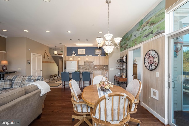 dining space with a notable chandelier, crown molding, and dark wood-type flooring