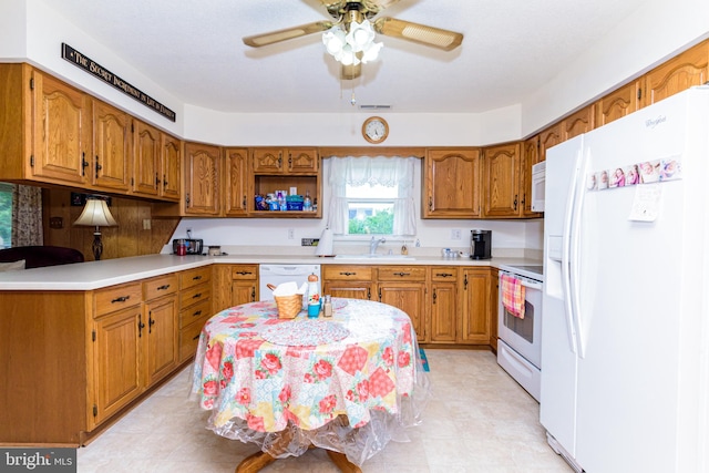 kitchen featuring white appliances, ceiling fan, and sink