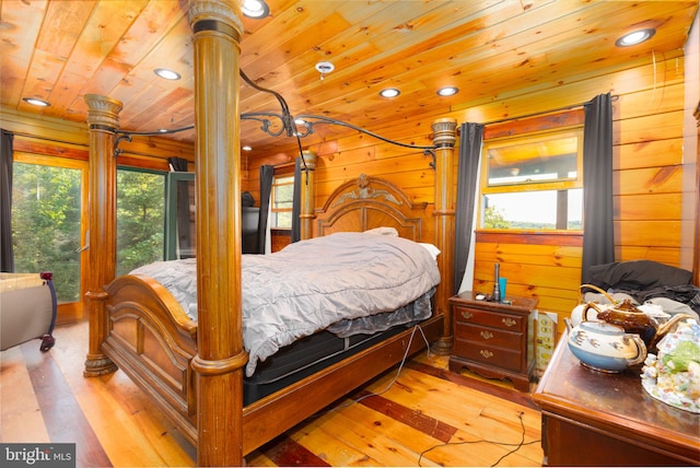 bedroom with light wood-type flooring, wood ceiling, wood walls, and multiple windows