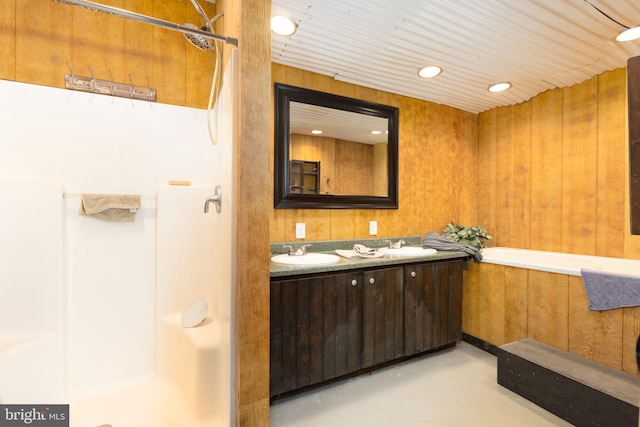 bathroom featuring concrete flooring, vanity, wooden walls, and independent shower and bath