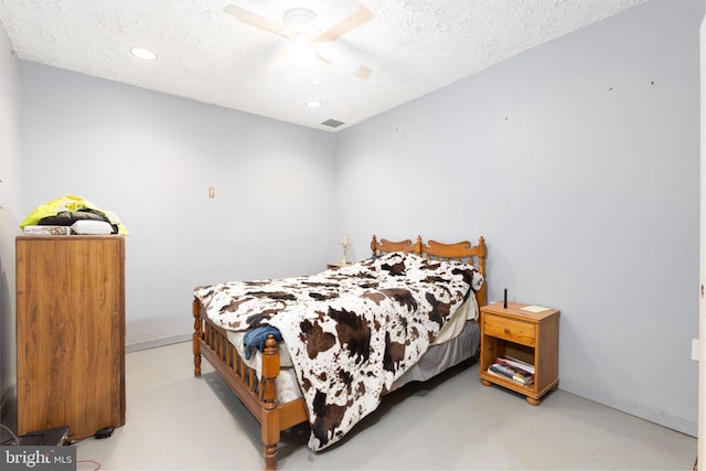 bedroom with ceiling fan and a textured ceiling