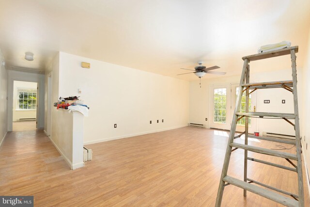 living room featuring light wood finished floors, baseboards, baseboard heating, and ceiling fan