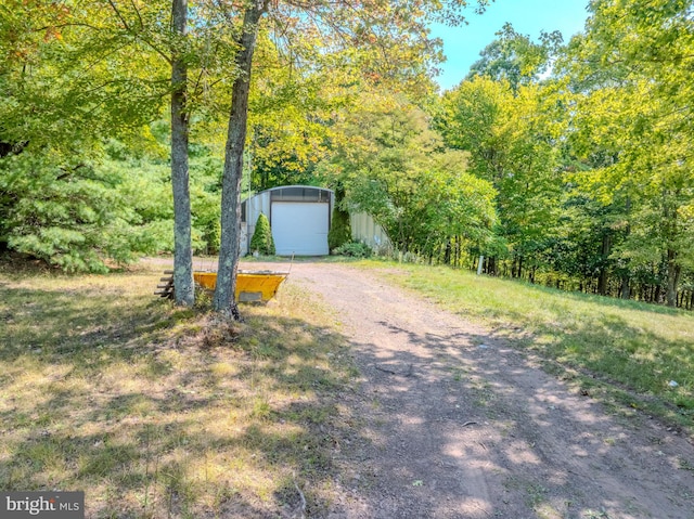 view of property hidden behind natural elements featuring an outbuilding