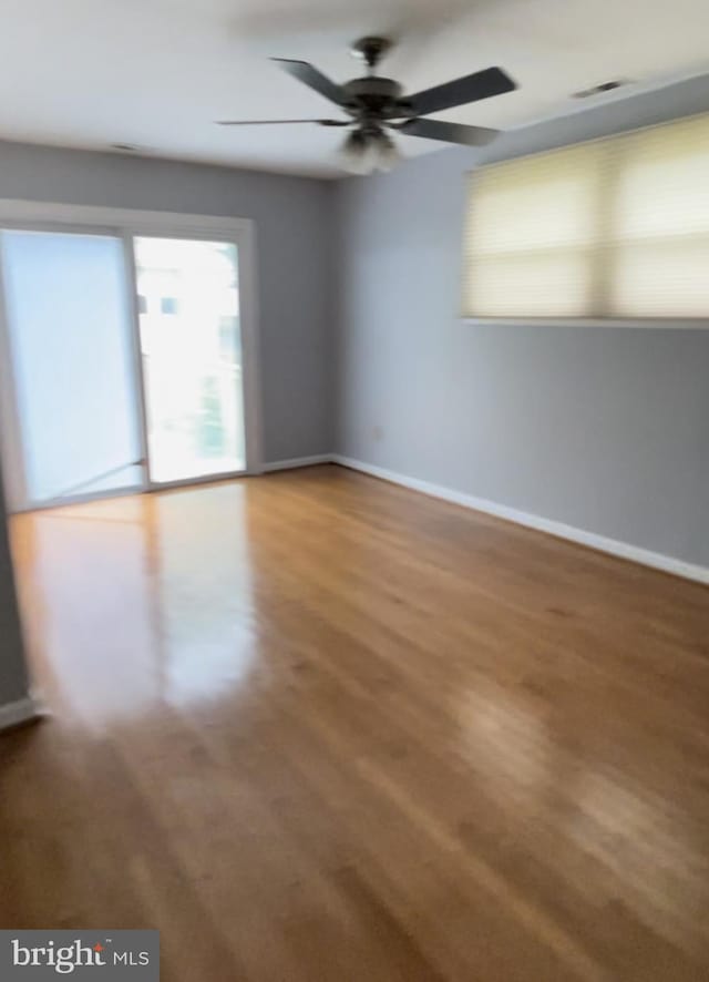 unfurnished room with hardwood / wood-style floors and ceiling fan