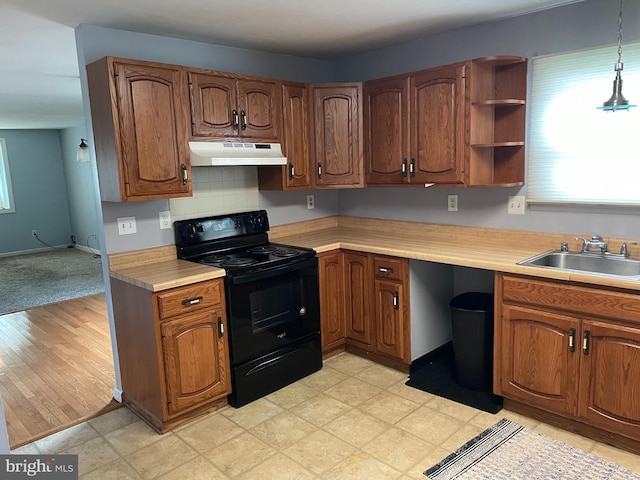 kitchen featuring decorative light fixtures, black range with electric stovetop, sink, and light hardwood / wood-style flooring