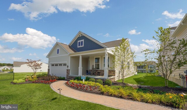 view of front of home featuring a garage, covered porch, and a front yard