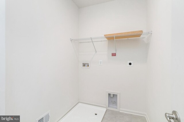 washroom featuring hookup for a washing machine, light tile patterned flooring, and electric dryer hookup