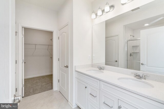 bathroom featuring tile patterned floors, walk in shower, and vanity