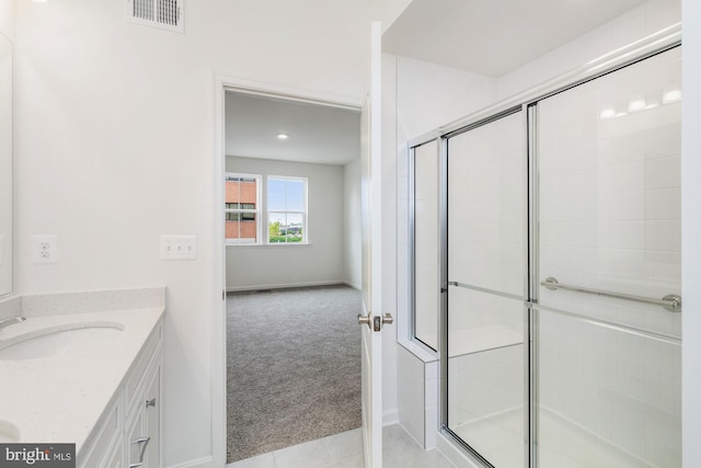 bathroom with vanity, a shower with shower door, and tile patterned floors