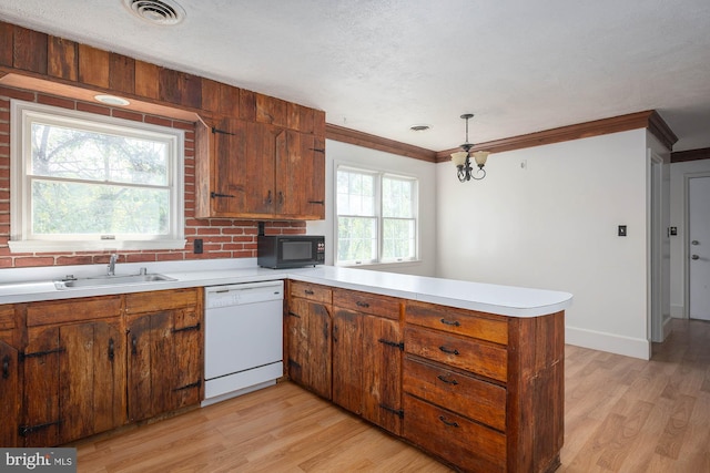 kitchen with white dishwasher, light wood-type flooring, kitchen peninsula, and a wealth of natural light