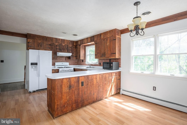 kitchen with light hardwood / wood-style floors, kitchen peninsula, and white appliances