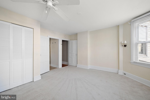 unfurnished bedroom with light carpet, multiple windows, and ceiling fan