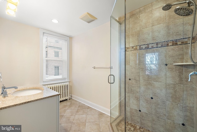 bathroom with vanity, a shower with door, tile patterned floors, and radiator