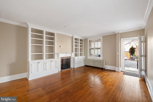 unfurnished living room with a fireplace, crown molding, radiator heating unit, and wood-type flooring