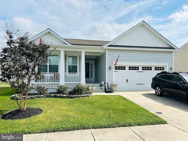 view of front of house with a front yard, a garage, and covered porch