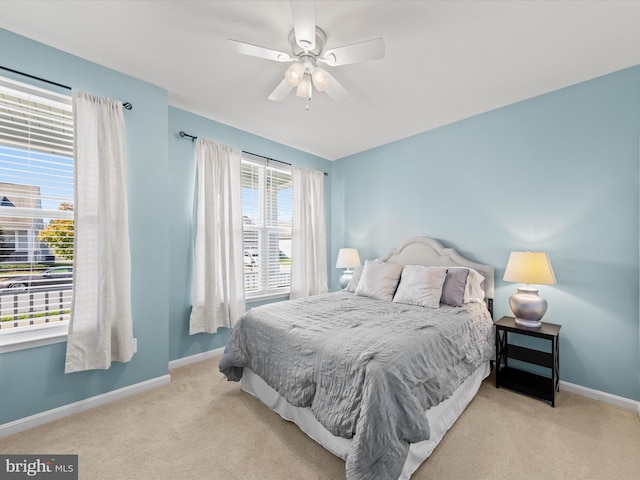 bedroom featuring light colored carpet, multiple windows, and ceiling fan