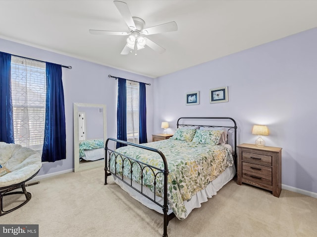 carpeted bedroom with ceiling fan and multiple windows