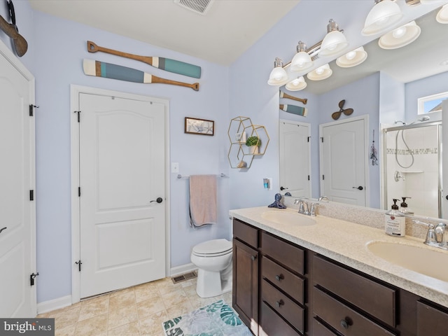 bathroom featuring vanity, a shower with shower door, toilet, and tile patterned flooring