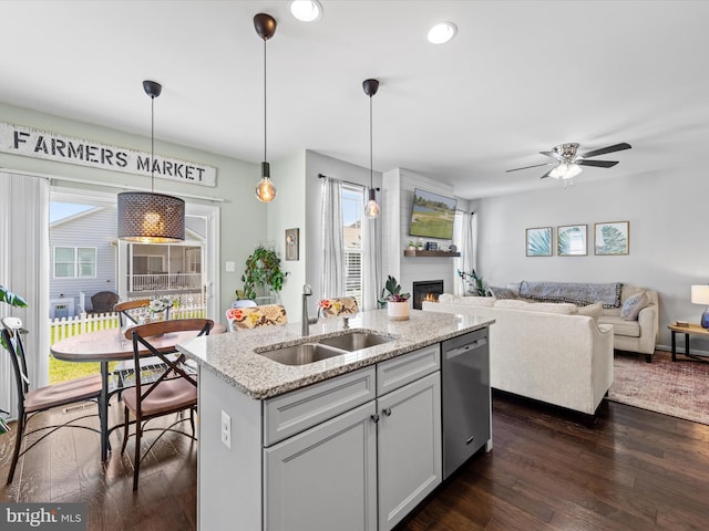 kitchen featuring dishwasher, plenty of natural light, sink, and an island with sink