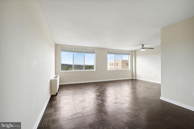 unfurnished room featuring ceiling fan and radiator heating unit