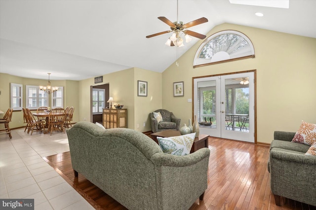 living room featuring ceiling fan, light wood-type flooring, vaulted ceiling, and a wealth of natural light