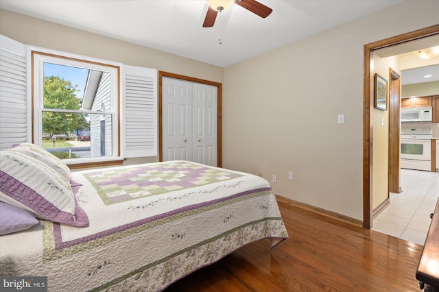 bedroom with ceiling fan, light hardwood / wood-style flooring, and a closet