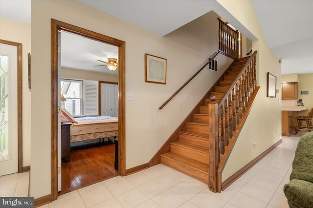 stairs featuring wood-type flooring and ceiling fan