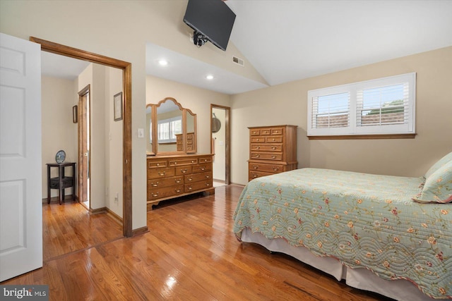 bedroom with lofted ceiling and hardwood / wood-style flooring