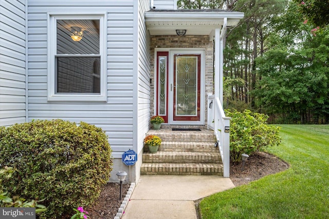 doorway to property with a lawn