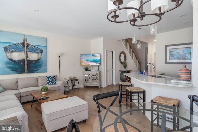 living room with a chandelier, hardwood / wood-style floors, and sink