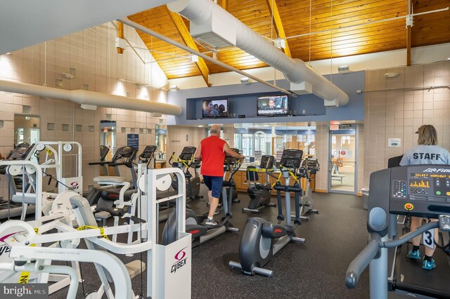 workout area with wooden ceiling, tile walls, and lofted ceiling