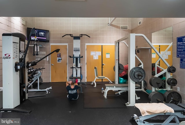 workout area featuring tile walls