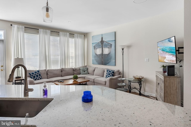 living room featuring a healthy amount of sunlight, sink, and hardwood / wood-style floors