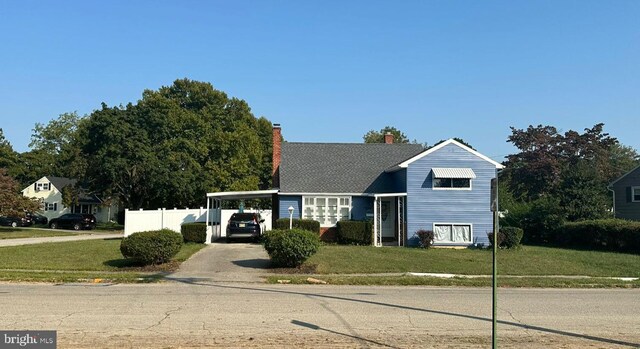 view of front of house featuring a carport and a front lawn