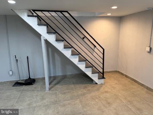 staircase featuring tile patterned flooring