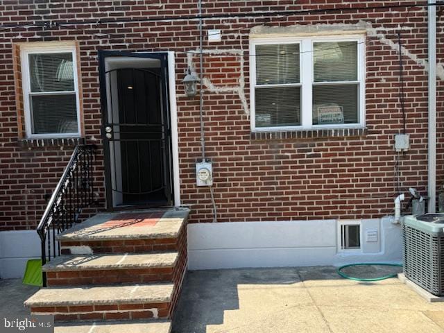 entrance to property with central air condition unit and a patio area