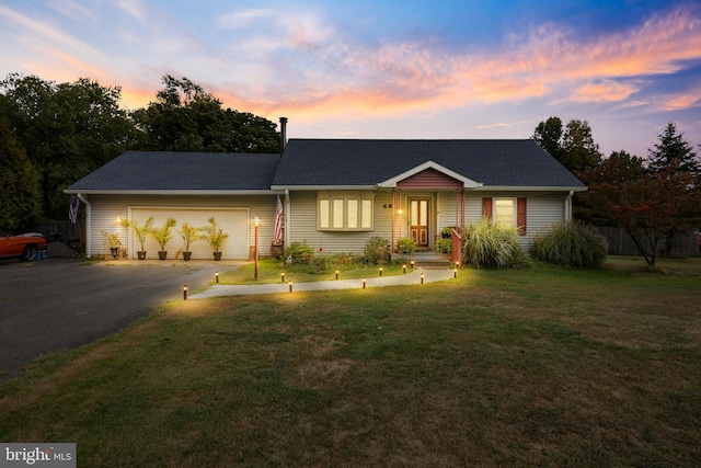 ranch-style home featuring a yard and a garage