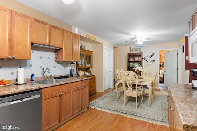 kitchen with decorative backsplash, light hardwood / wood-style floors, dishwasher, ceiling fan, and sink