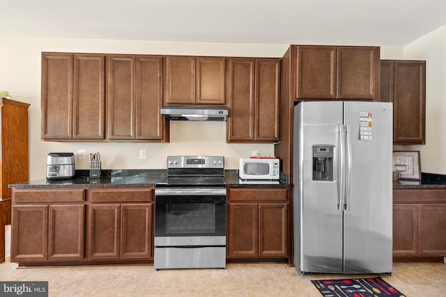 kitchen featuring dark stone countertops and stainless steel appliances