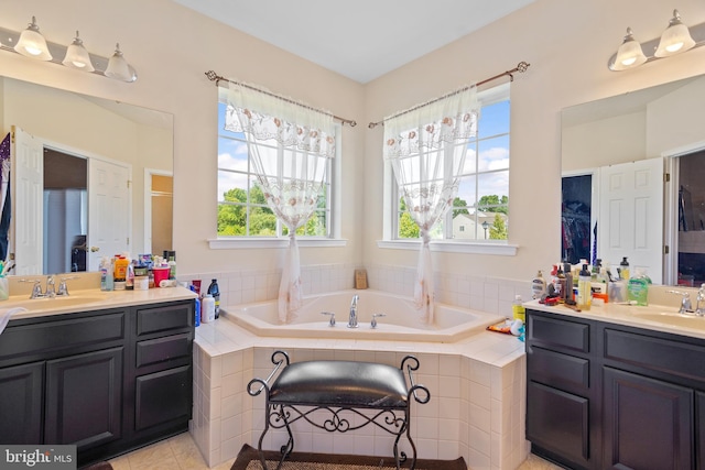 bathroom featuring tile patterned floors, plenty of natural light, tiled bath, and vanity