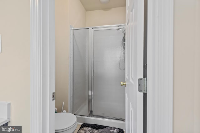 bathroom featuring an enclosed shower and toilet