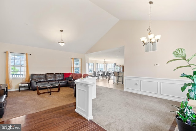 living room featuring high vaulted ceiling, a chandelier, and carpet flooring