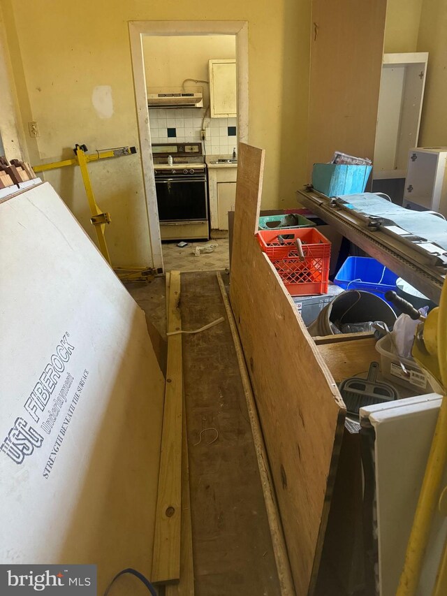 interior space with decorative backsplash and range with electric stovetop