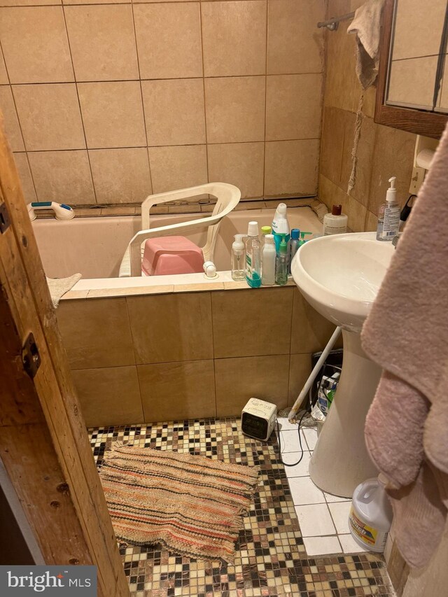 bathroom with tile walls and tile patterned flooring