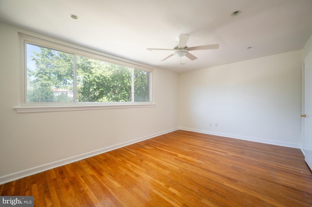 empty room with ceiling fan and hardwood / wood-style flooring